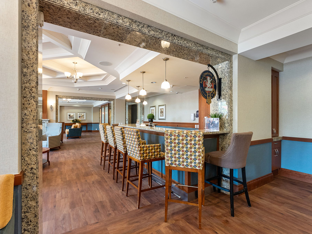 Lobby of Walden Circle Retirement Home featuring a bar and comfortable seating area with chairs.