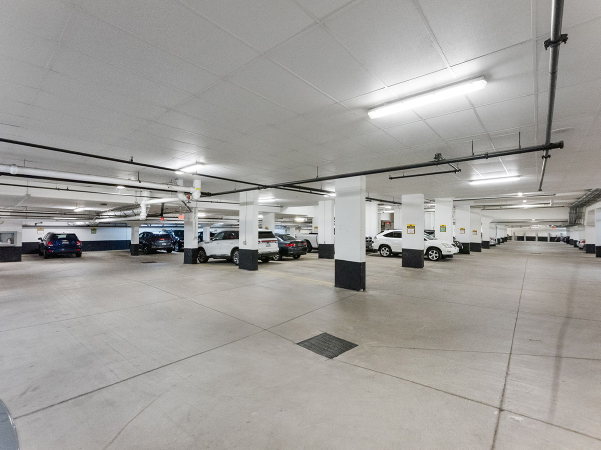 An empty Walden Circle Retirement Home garage with several cars parked throughout the spacious area.