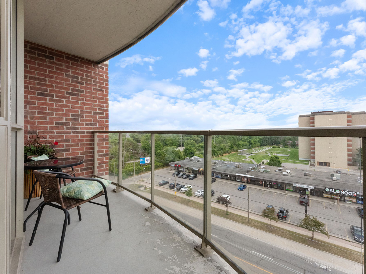 A balcony at Walden Circle Retirement Home features a table and chairs with a view of the adjacent parking lot.