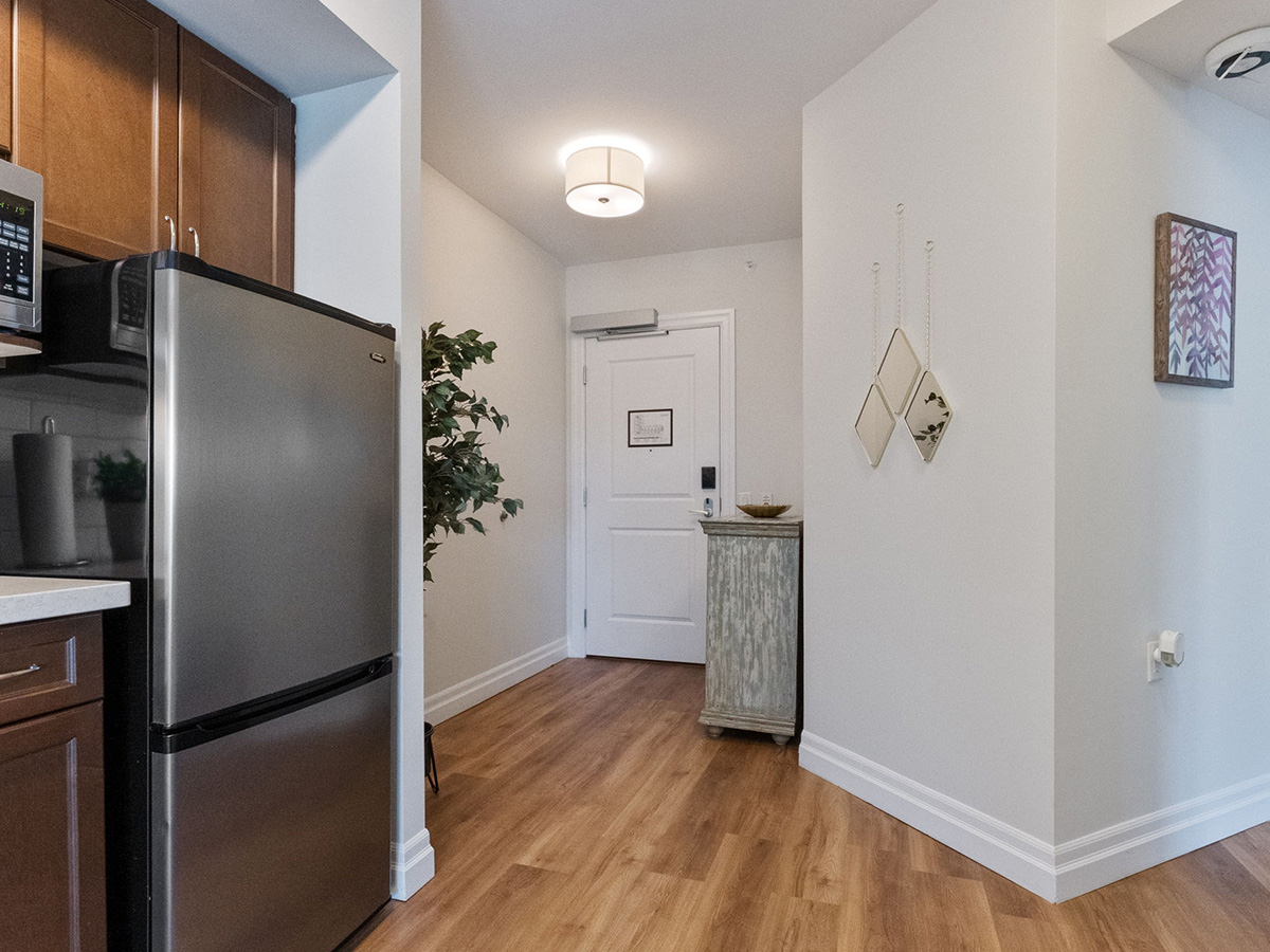 Kitchen with sleek stainless steel appliances and elegant wooden floors, showcasing Walden Circle Retirement Home suites.